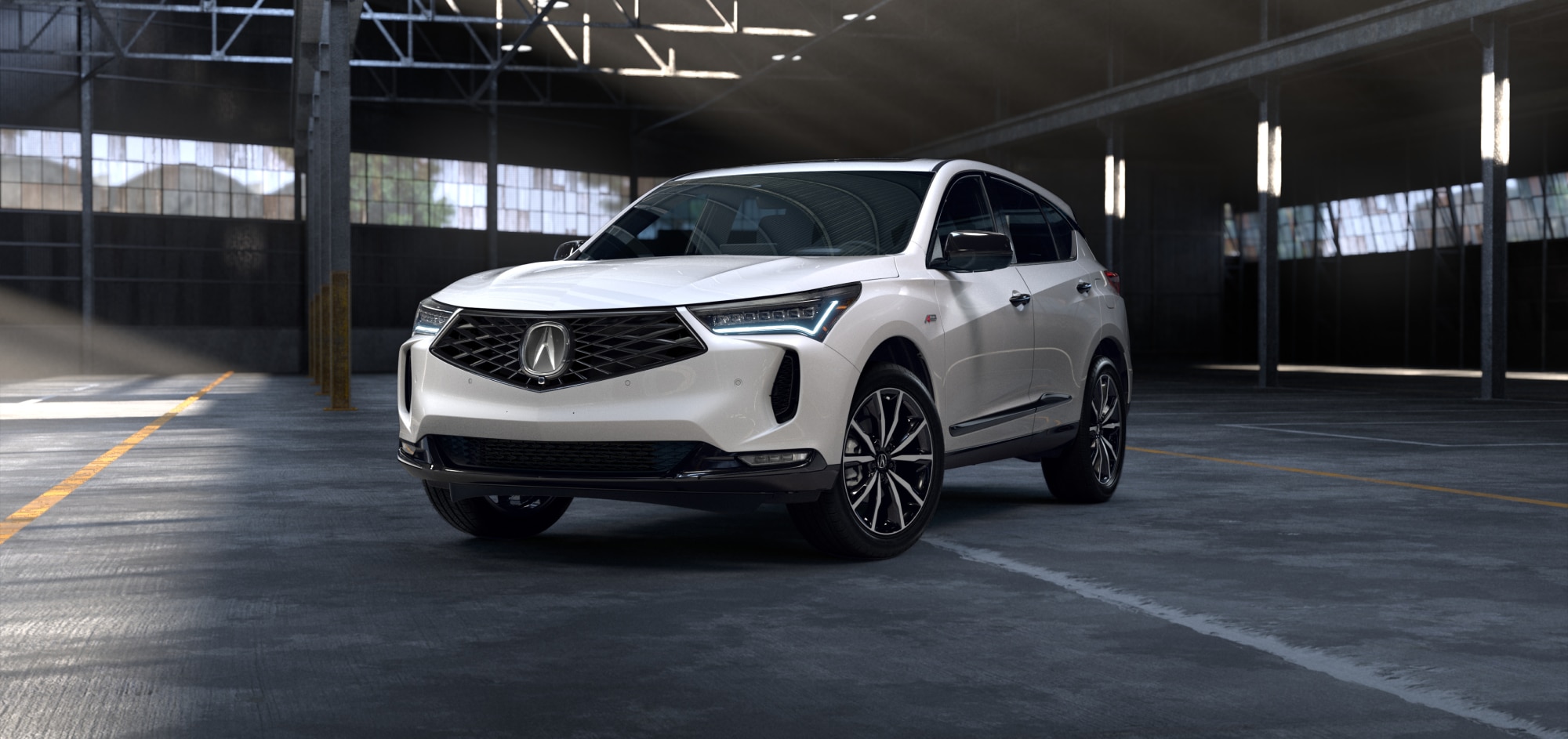 Side driver-side view of white 2025 RDX parked inside an empty warehouse.