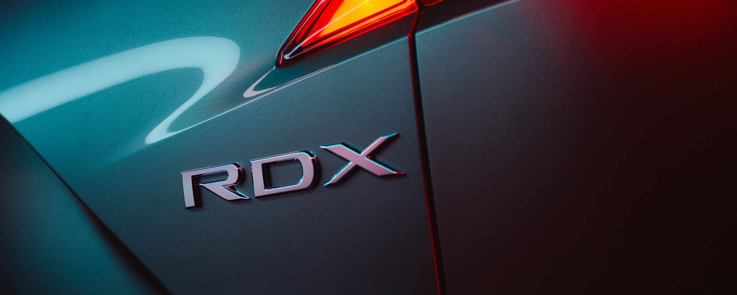 Gros plan sur les badges RDX et SH-AWD sur un RDX gris.