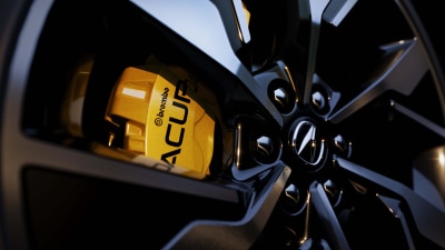 Closeup of yellow caliper on an Acura wheel.