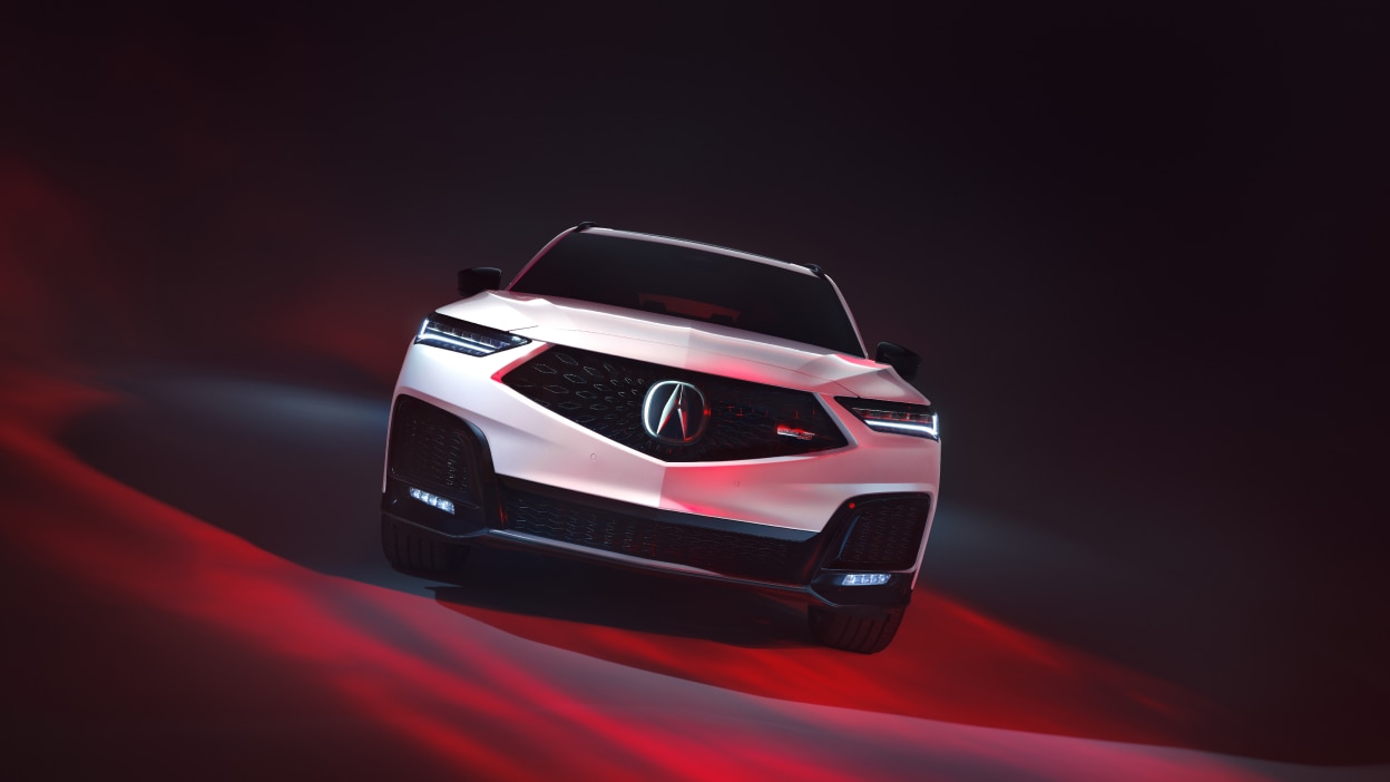 MDX gris circulant en pleine nature sur une route enneigée.