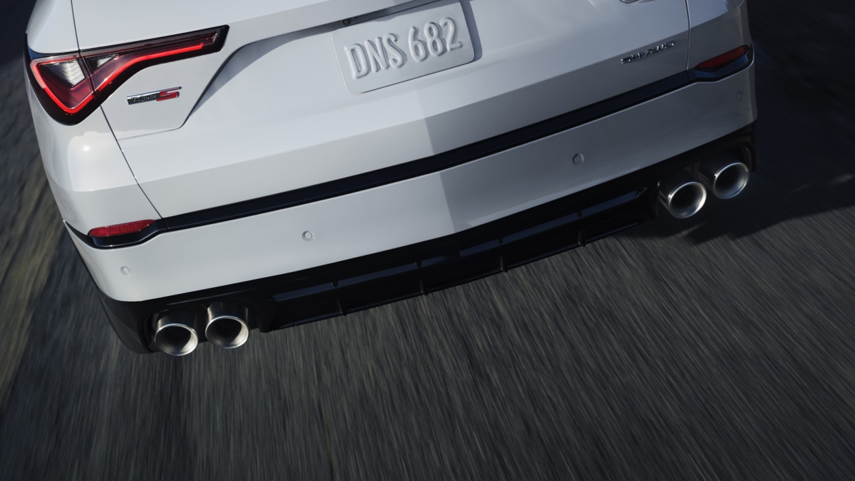 MDX rouge qui prend un virage en pleine nature.